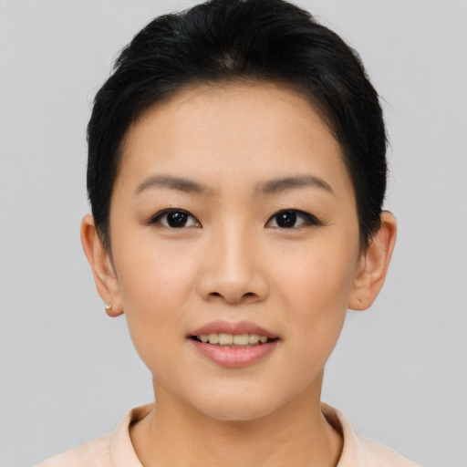 Joyful asian young-adult female with short  black hair and brown eyes