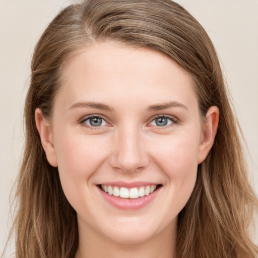 Joyful white young-adult female with long  brown hair and blue eyes