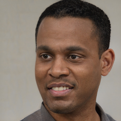 Joyful black young-adult male with short  black hair and brown eyes