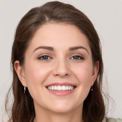 Joyful white young-adult female with long  brown hair and grey eyes