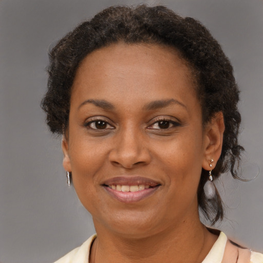 Joyful black adult female with short  brown hair and brown eyes