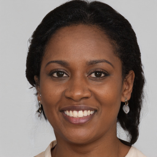 Joyful black young-adult female with long  black hair and brown eyes