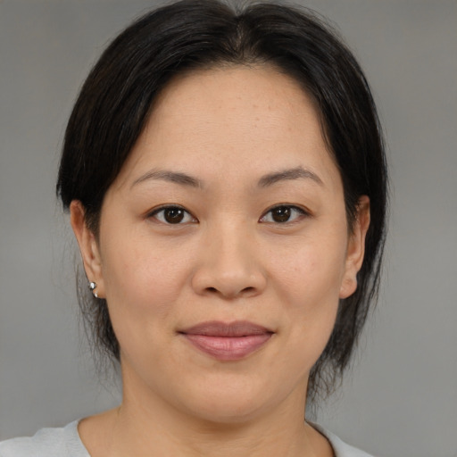 Joyful asian adult female with medium  brown hair and brown eyes