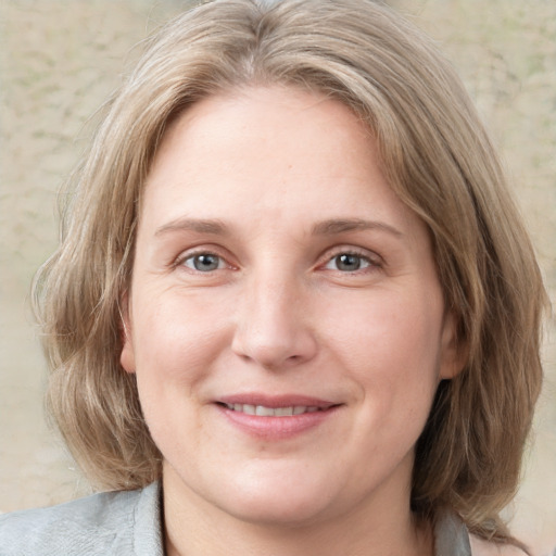 Joyful white adult female with medium  brown hair and grey eyes