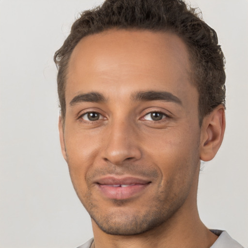 Joyful latino young-adult male with short  brown hair and brown eyes