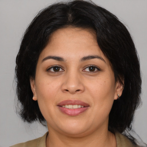 Joyful latino young-adult female with medium  brown hair and brown eyes