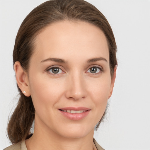 Joyful white young-adult female with medium  brown hair and grey eyes