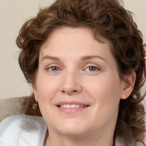 Joyful white adult female with medium  brown hair and green eyes