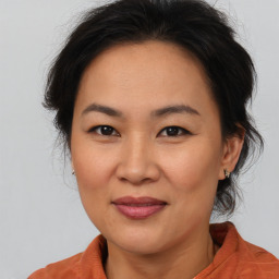 Joyful asian adult female with medium  brown hair and brown eyes