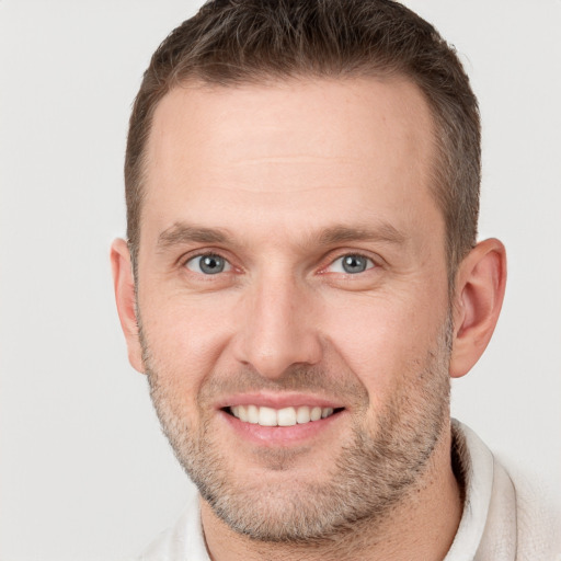 Joyful white adult male with short  brown hair and grey eyes