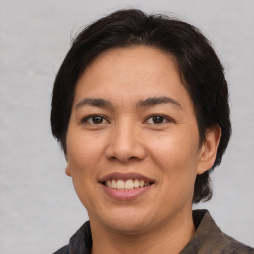 Joyful asian young-adult female with short  brown hair and brown eyes