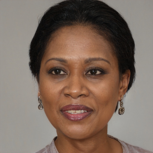 Joyful black adult female with medium  brown hair and brown eyes