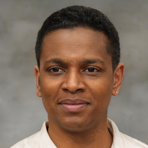 Joyful black adult male with short  black hair and brown eyes