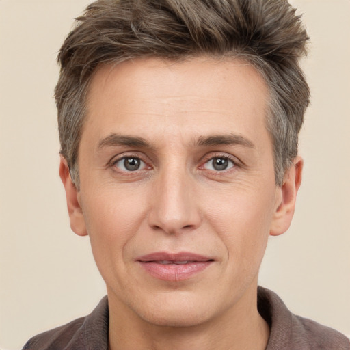 Joyful white adult male with short  brown hair and grey eyes