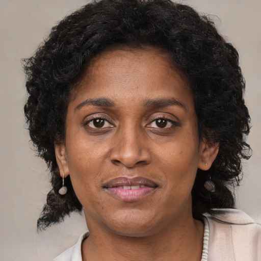 Joyful black adult female with medium  brown hair and brown eyes