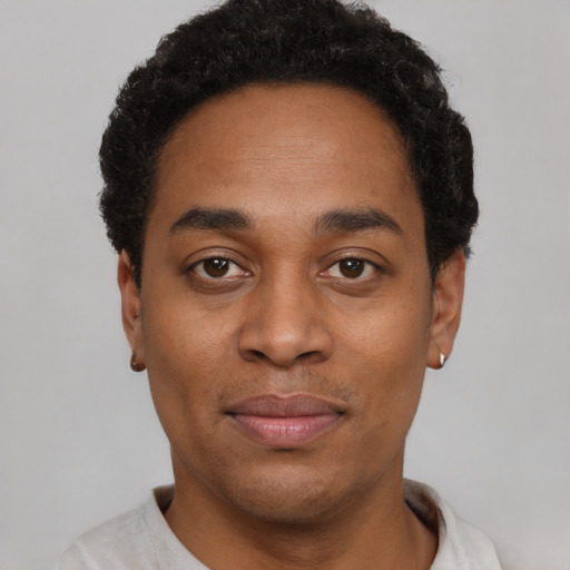Joyful black young-adult male with short  brown hair and brown eyes