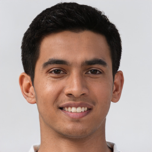 Joyful latino young-adult male with short  brown hair and brown eyes
