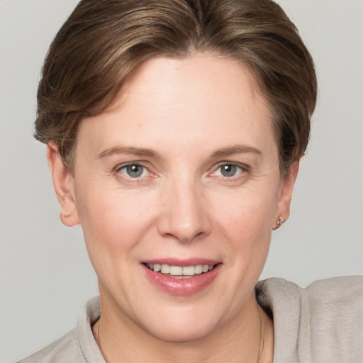 Joyful white young-adult female with short  brown hair and grey eyes