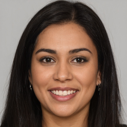 Joyful latino young-adult female with long  brown hair and brown eyes