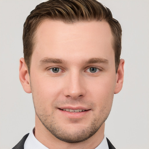 Joyful white young-adult male with short  brown hair and grey eyes