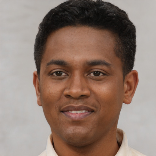 Joyful latino young-adult male with short  black hair and brown eyes