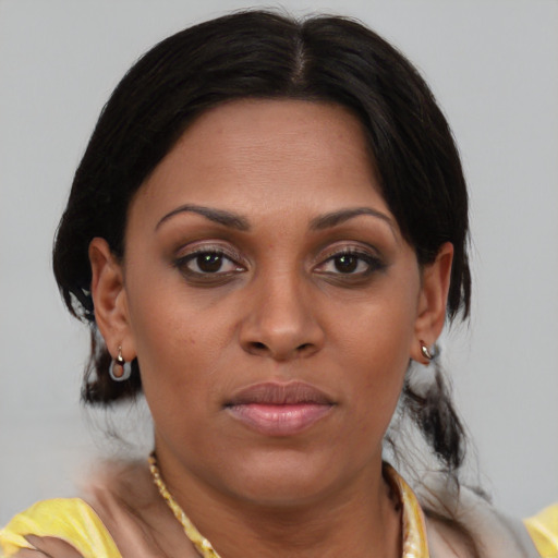 Joyful black young-adult female with medium  brown hair and brown eyes