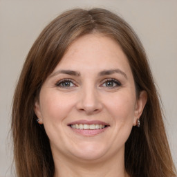 Joyful white young-adult female with long  brown hair and grey eyes