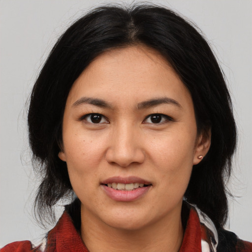 Joyful asian adult female with medium  brown hair and brown eyes