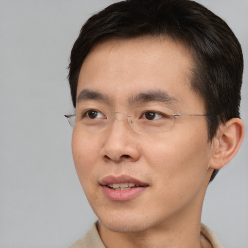 Joyful asian adult male with short  brown hair and brown eyes