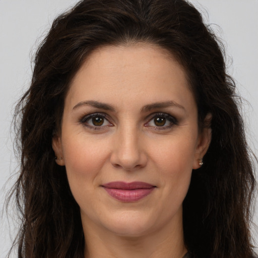 Joyful white adult female with long  brown hair and brown eyes