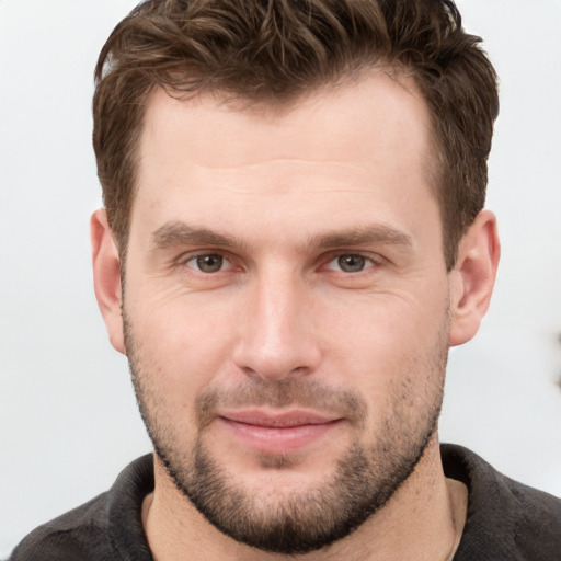 Joyful white young-adult male with short  brown hair and grey eyes