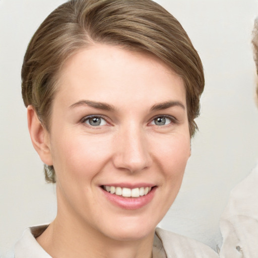 Joyful white young-adult female with medium  brown hair and grey eyes