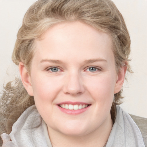 Joyful white young-adult female with medium  brown hair and blue eyes