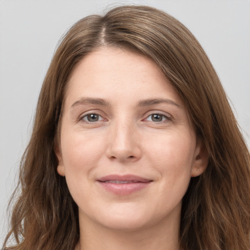 Joyful white young-adult female with long  brown hair and grey eyes