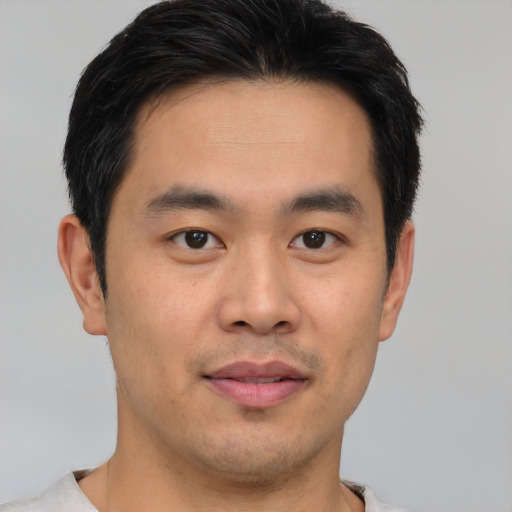Joyful asian young-adult male with short  black hair and brown eyes