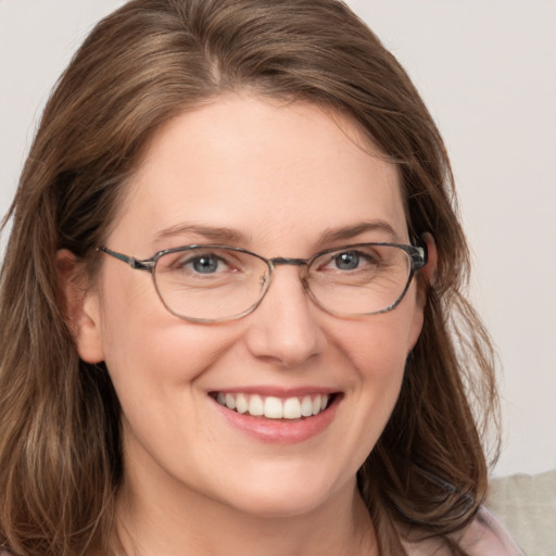 Joyful white adult female with medium  brown hair and blue eyes