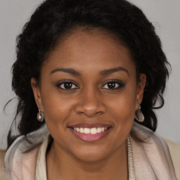 Joyful black young-adult female with long  brown hair and brown eyes