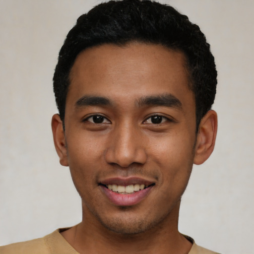 Joyful latino young-adult male with short  black hair and brown eyes