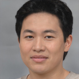 Joyful asian young-adult male with short  black hair and brown eyes