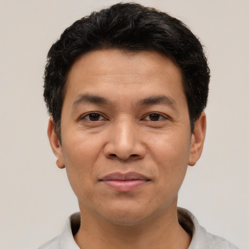 Joyful latino adult male with short  brown hair and brown eyes
