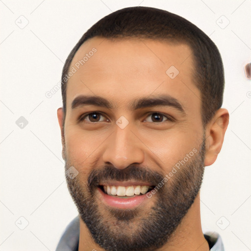 Joyful latino young-adult male with short  black hair and brown eyes