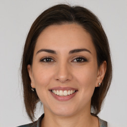 Joyful white young-adult female with medium  brown hair and brown eyes