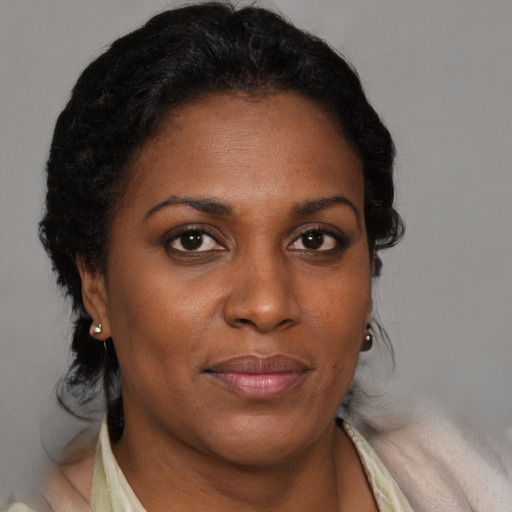 Joyful black adult female with short  brown hair and brown eyes