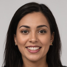 Joyful latino young-adult female with long  brown hair and brown eyes