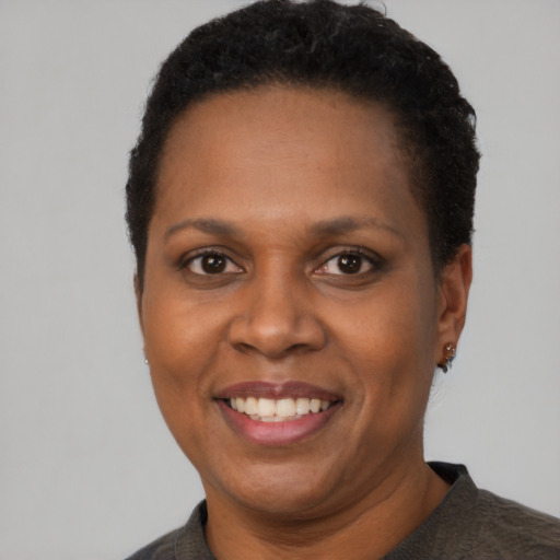 Joyful black adult female with short  black hair and brown eyes