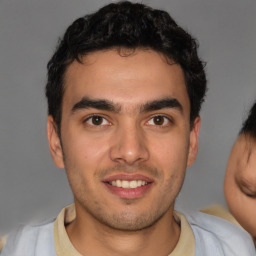 Joyful latino young-adult male with short  brown hair and brown eyes