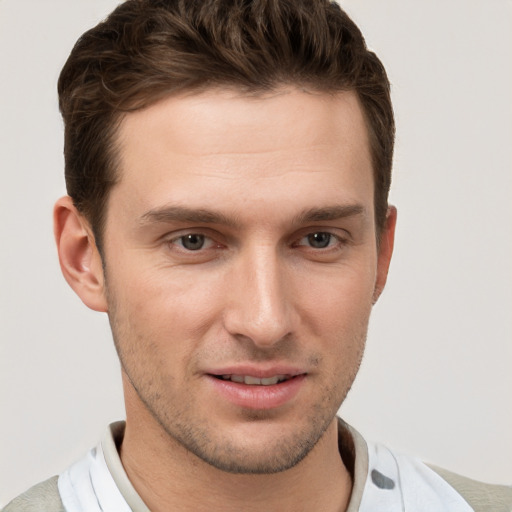 Joyful white young-adult male with short  brown hair and grey eyes