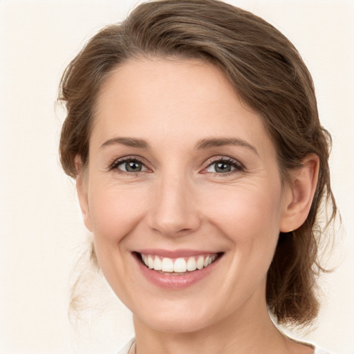 Joyful white young-adult female with medium  brown hair and grey eyes