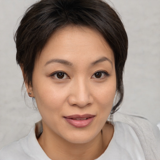 Joyful asian young-adult female with medium  brown hair and brown eyes