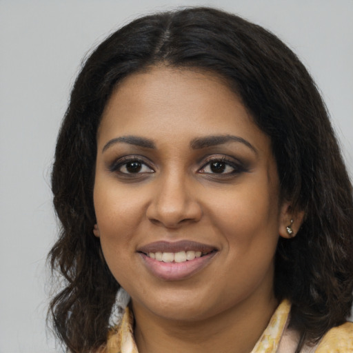 Joyful black young-adult female with long  brown hair and brown eyes